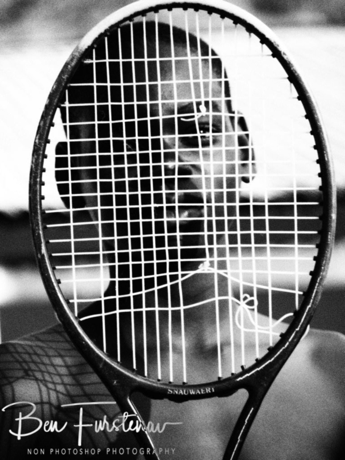 Hiding behind a racket in Chembe, Cape Maclear, Lake Malawi, Malawi
