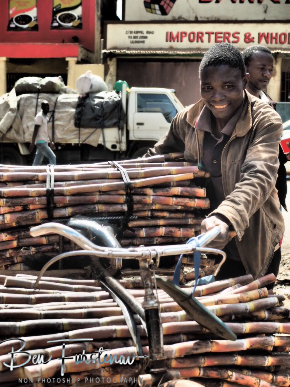 Trying to smile whilst pushing heavy load in Lilongwe, Malawi 