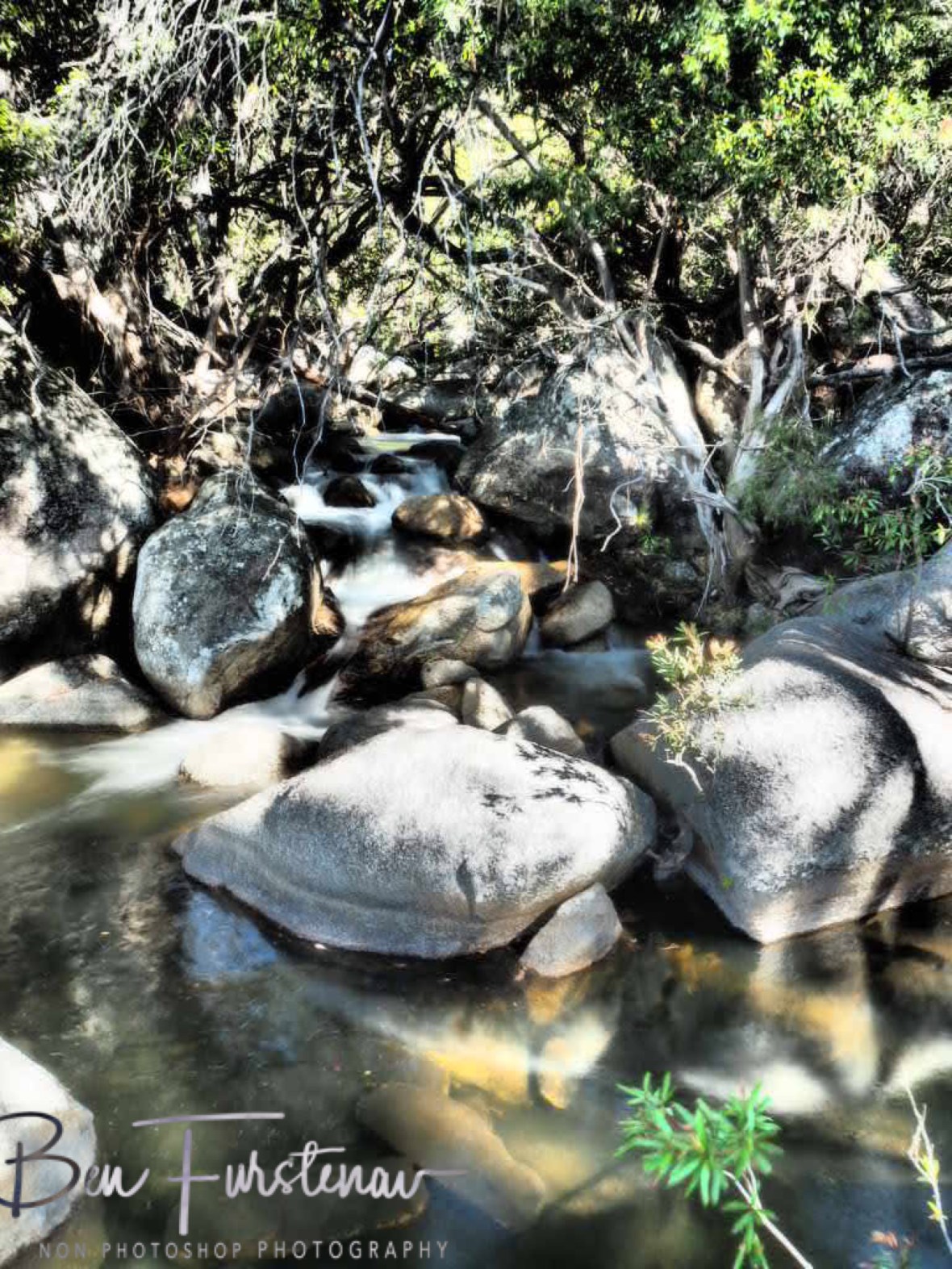 Submerged boulders in clear waters at Emerald Creek Falls, Atherton Tablelands, Far North Queensland, Australia
